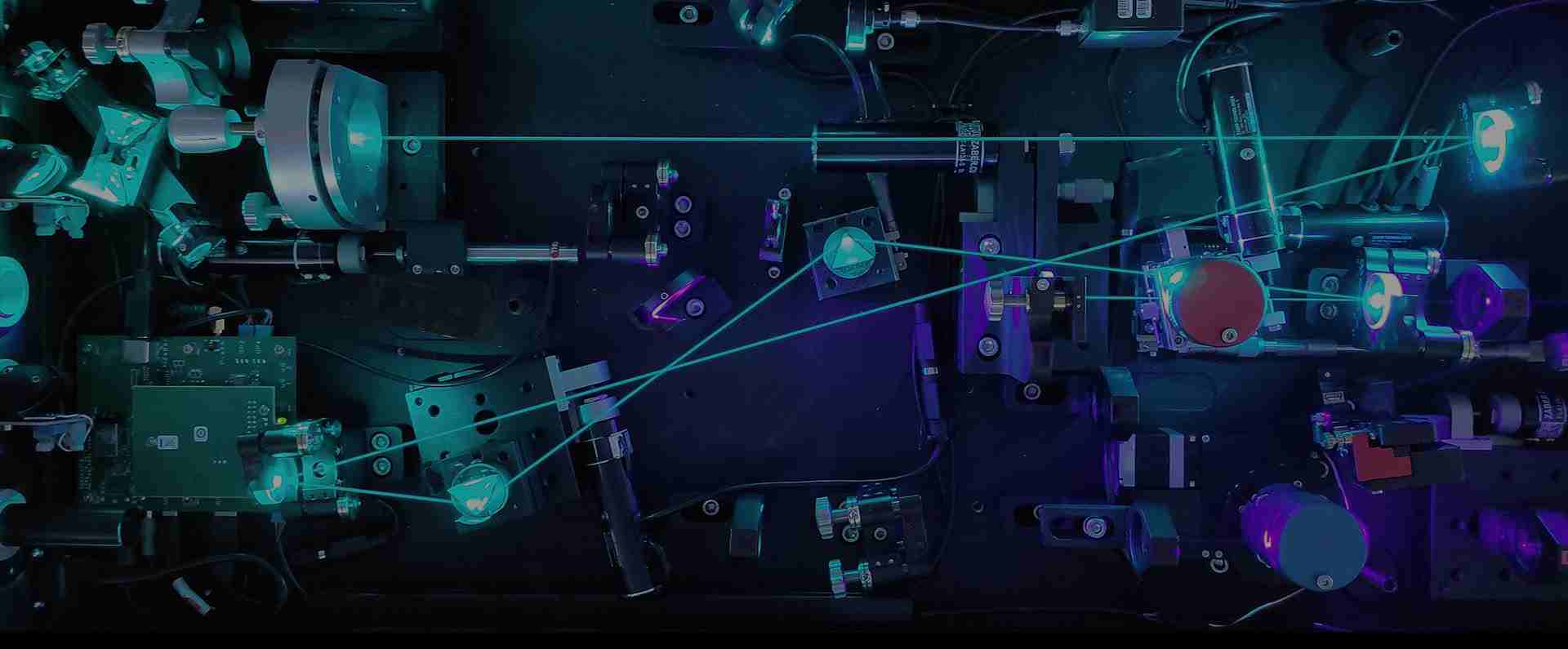 Optical table with a tunable laser setup and cyan beam paths